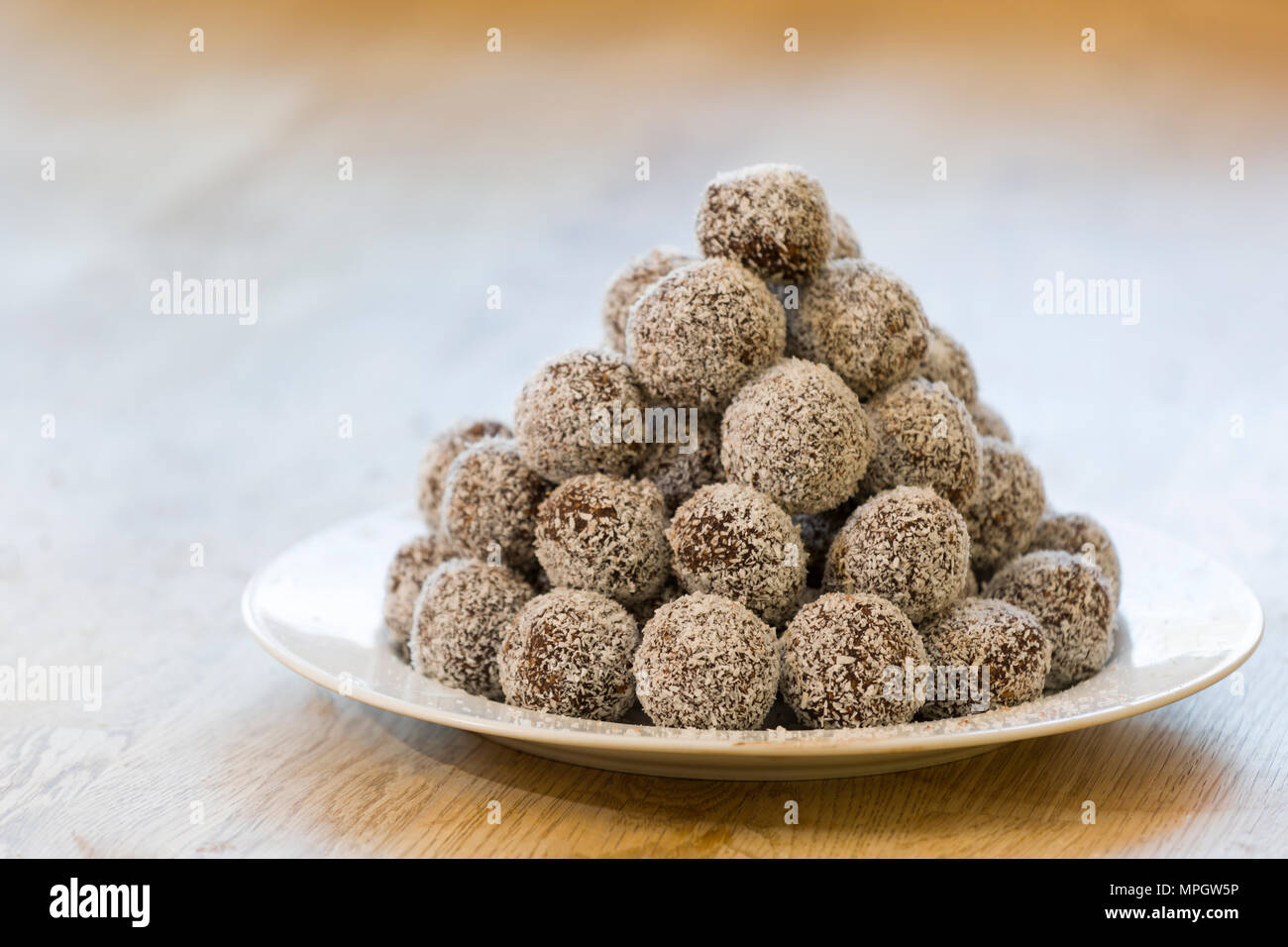 Platte mit hausgemachte Schokolade Kugeln zerfetzten Kokosraspeln bedeckt gefüllt Stockfoto