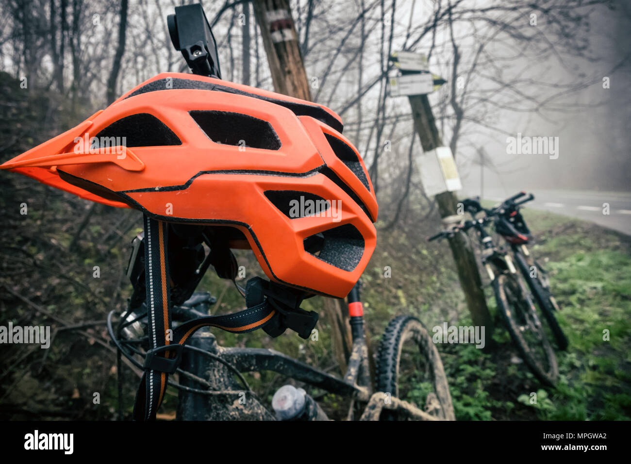 Mountainbike und Fahrradhelm im Herbst Wald. MTB Fahrrad und Helm auf Baum im Wald. Abenteuer und extreme Radfahren Konzept, Sport fitne Stockfoto