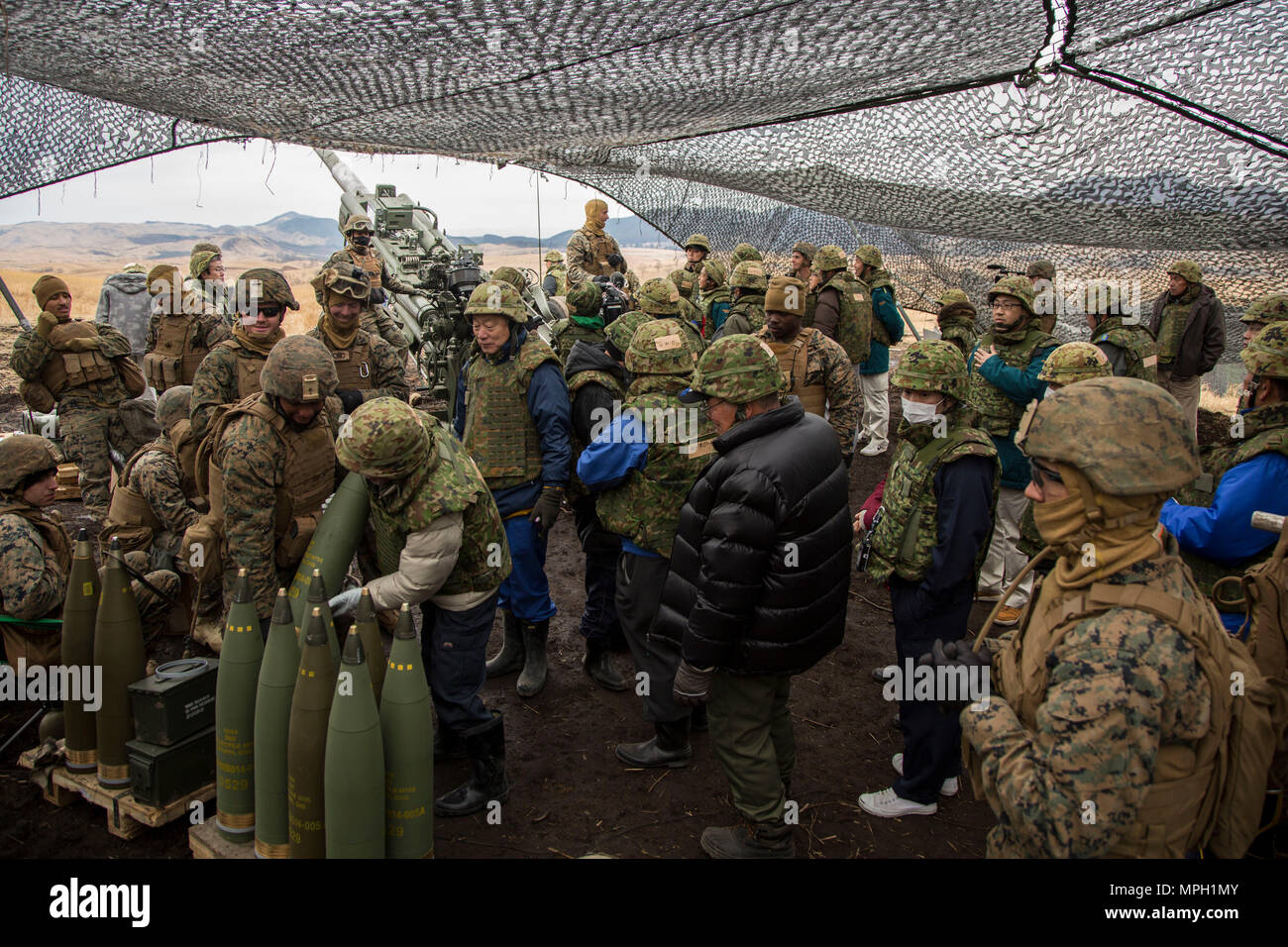 Us-Marines und Matrosen mit Alpha Batterie, 1.Bataillon, 12 Marines, derzeit zu Alpha Akku, 3.Bataillon, 12 Marines Waffensysteme und Funktionen für lokale Reporter in der Hijudai Manöver, Japan, 1. März 2017. Marinesoldaten und Matrosen an der Artillerie relocation Training Programm rechtzeitige und genaue Brände zu stellen militärische beruflichen Spezialgebiet Fähigkeiten, Zug Marines/Matrosen in gemeinsamen Fähigkeiten zu erhalten, und professionelle militärische Ausbildung für das allgemeine Ziel der Verbesserung der Bekämpfung der Betriebsbereitschaft und internationale Beziehungen zu fördern. (U.S. Stockfoto