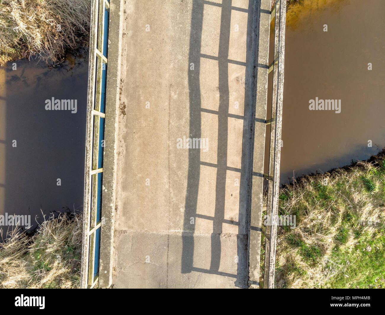 Luftaufnahme aus geringer Höhe von 10 Metern von einer kleinen Brücke über einem dunklen Stream, mit Drone Stockfoto