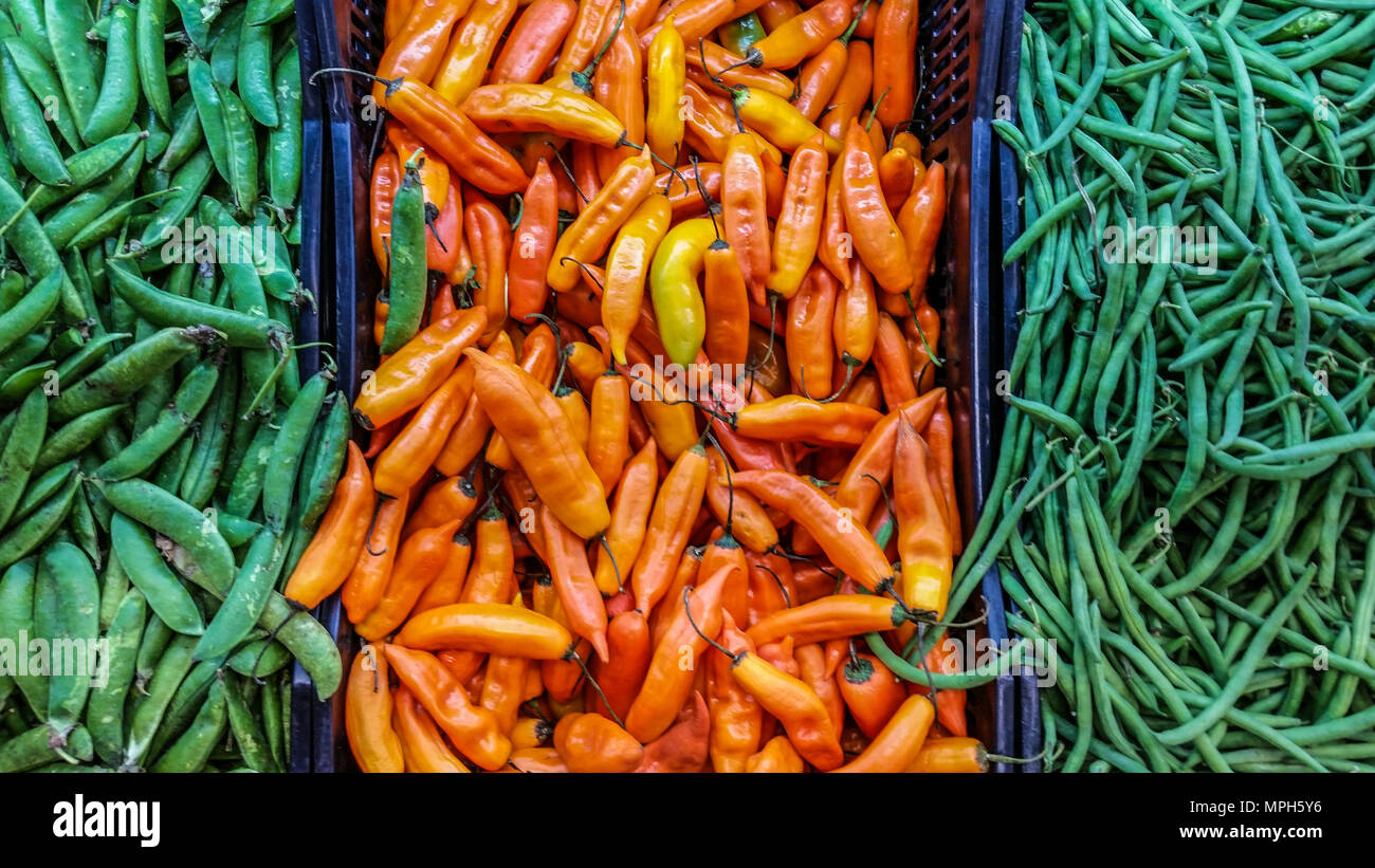 Bunte Bild, Makro Top view Nahaufnahme von Chili peppers - Erbsen und Bohnen in Boxen im Freien Stockfoto
