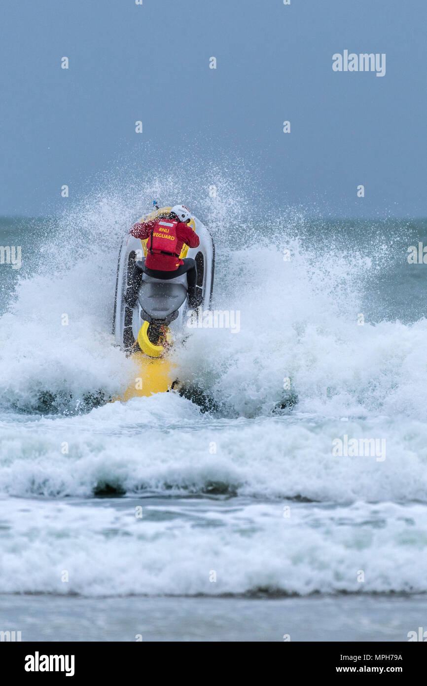 Ein rnli Rettungsschwimmer Reiten eine Rettung jetski an Fistral in Newquay in Cornwall. Stockfoto