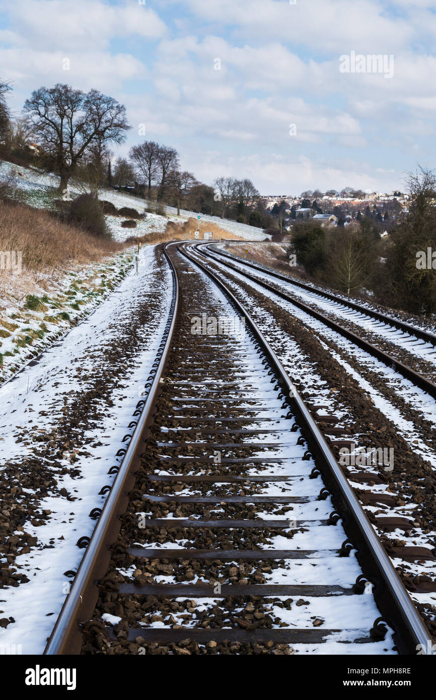 Verschneite Gleise durch eine ländliche Umgebung. Stockfoto