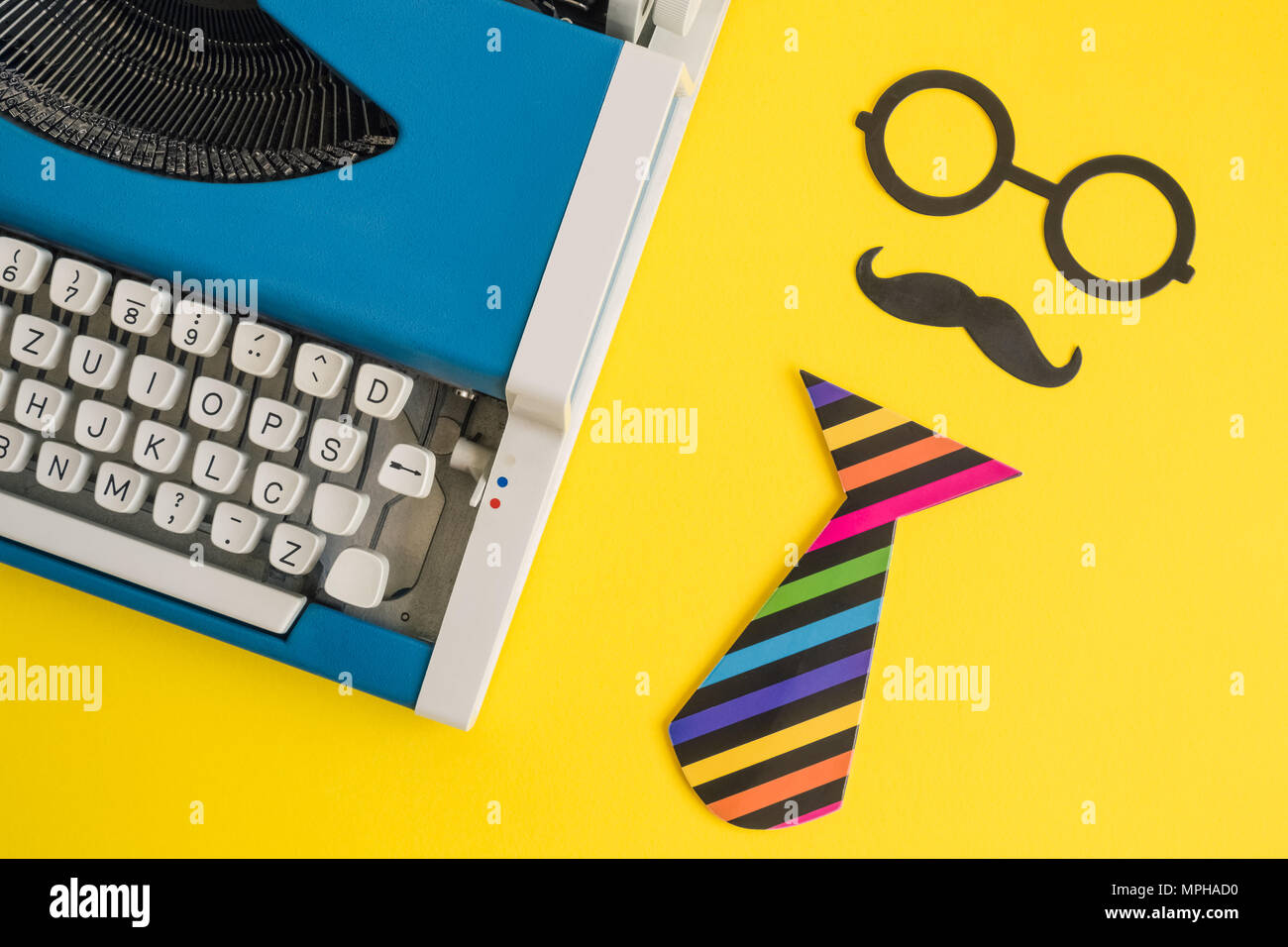 Flach vintage blau Schreibmaschine und Papier stützen in Form von Retro hipster Mann auf gelben Hintergrund minimal kreatives Konzept. Stockfoto