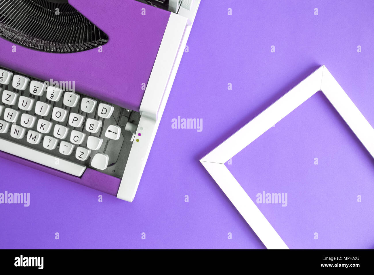 Retro Vintage Schreibmaschine und Bilderrahmen violett minimal kreatives Konzept. Stockfoto