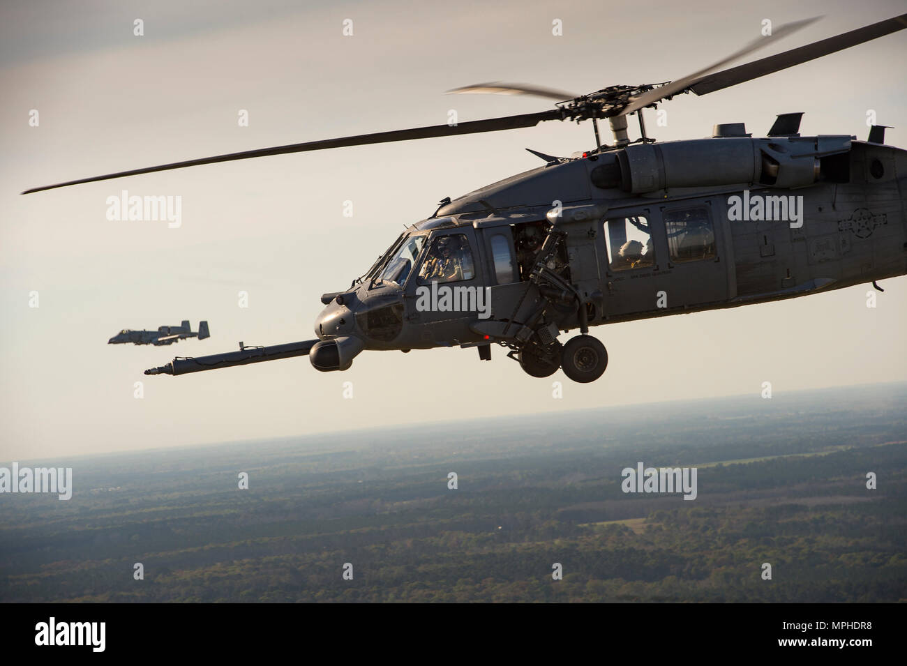 Ein HH-60G Pave Hawk und eine A-10 Thunderbolt II C fliegen als Teil einer Suche und Rettung Demonstration während des 75-jährigen Bestehens Flying Tiger Reunion, 10. März 2017, bei Moody Air Force Base, Ga 1941, Präsident Roosevelt unterzeichnete eine Executive Order bildet die amerikanische Gruppe von Freiwilligen. Die AVG wurde in der 1., 2., und 3. der Verfolgung Schwadronen und später aufgelöst und durch die 23d Fighter Group im Jahre 1942 ersetzt. Unter dem Kommando von General Claire Chennault, die Flying Tigers aus der 74., 75., und 76. der Verfolgung Staffeln China gegen die Japaner zu verteidigen. Der ganzen Welt Wa Stockfoto