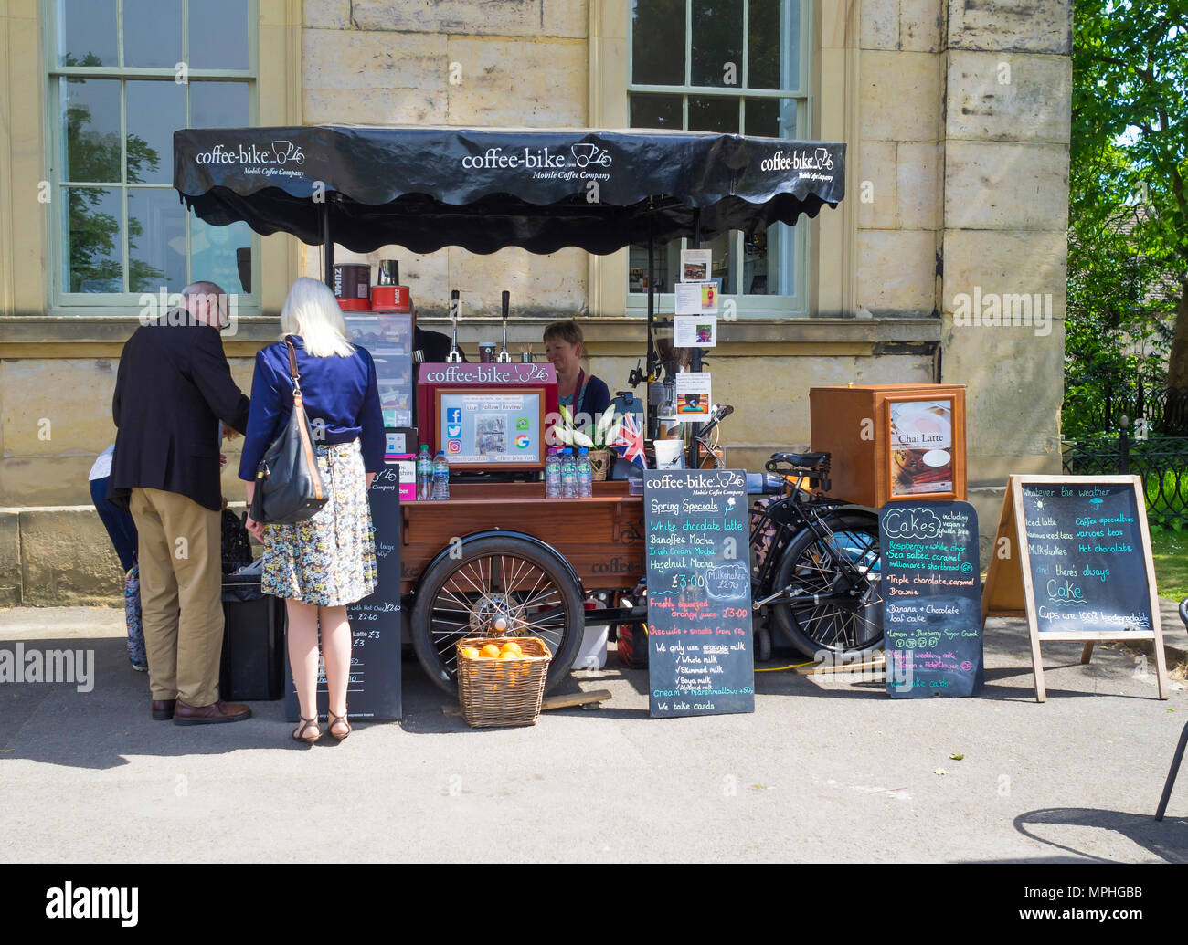 Ein Mann und eine Frau von einem tragbaren Erfrischungen kaufen, Kaffee und Kuchen auf einen Kaffee im Museum Park York Abschaltdruck Stockfoto