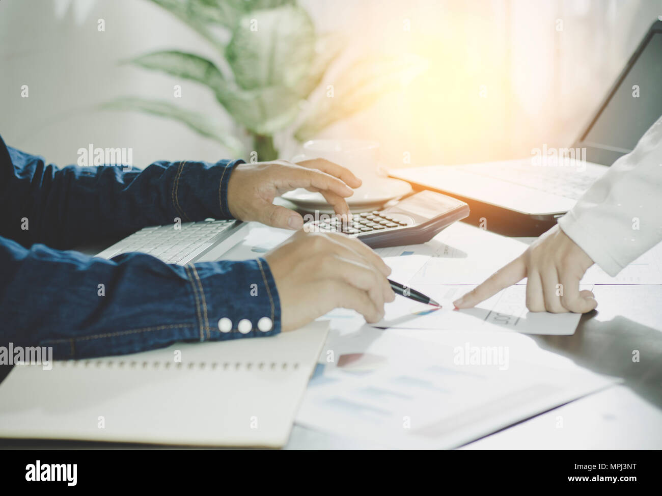 Berechnen budget Business Planung Konzept, zwei Menschen couting Einnahmen und Ausgaben durch den Einsatz von Taschenrechner und Papier Grafik auf Schreibtisch in Home Stockfoto
