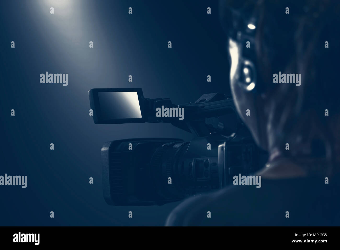 Video Operator mit Videokamera und Kopfhörer realisiert ein Live video Shooting. Nebel Bild mit neutralen Farbe dominanz. Stockfoto
