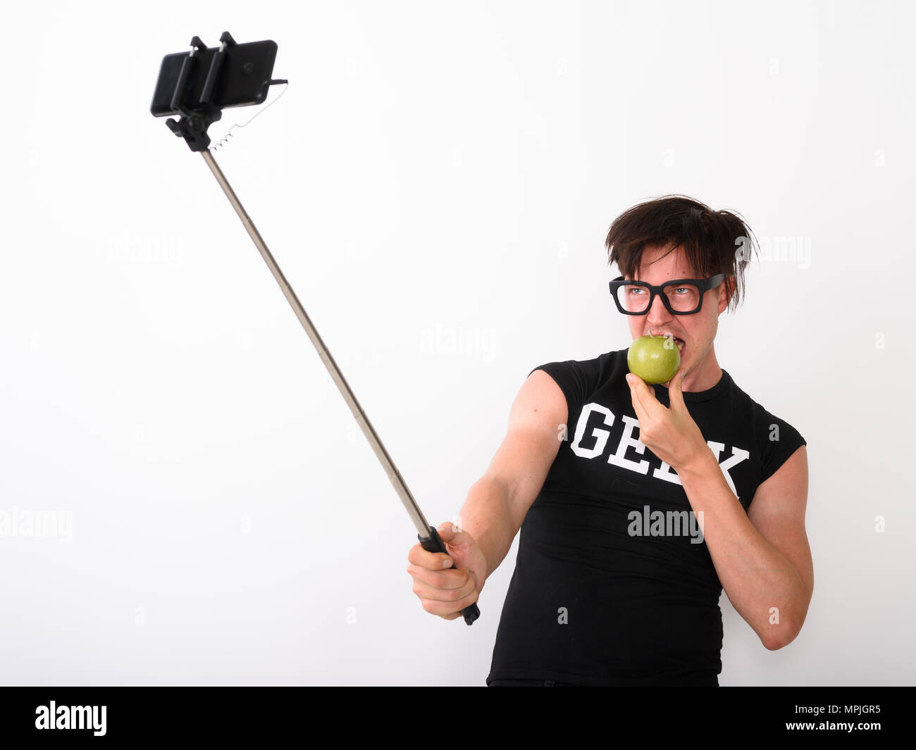 Studio shot der glücklichen jungen gutaussehenden nerd Mann lächelnd, während Takin Stockfoto