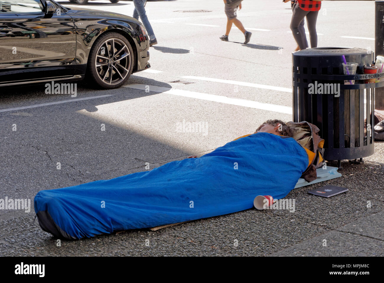 Jungen Obdachlosen schlafen auf dem Bürgersteig in der Innenstadt von Vancouver, BC, Kanada Stockfoto
