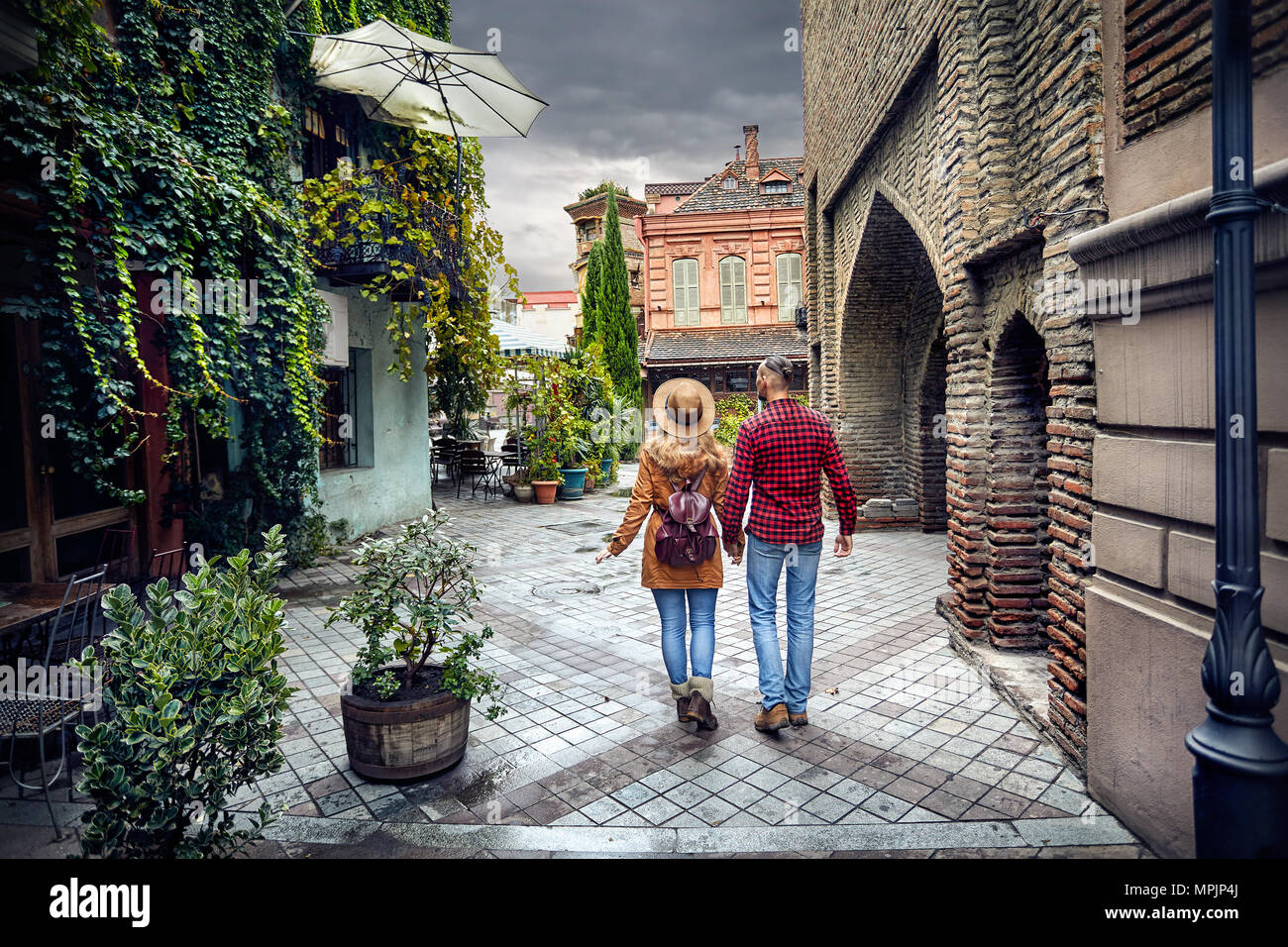 Touristische Frau in braunen Hut und Mann im roten Hemd, wandern die alten Straßen im Zentrum von Tiflis, Georgien Stockfoto