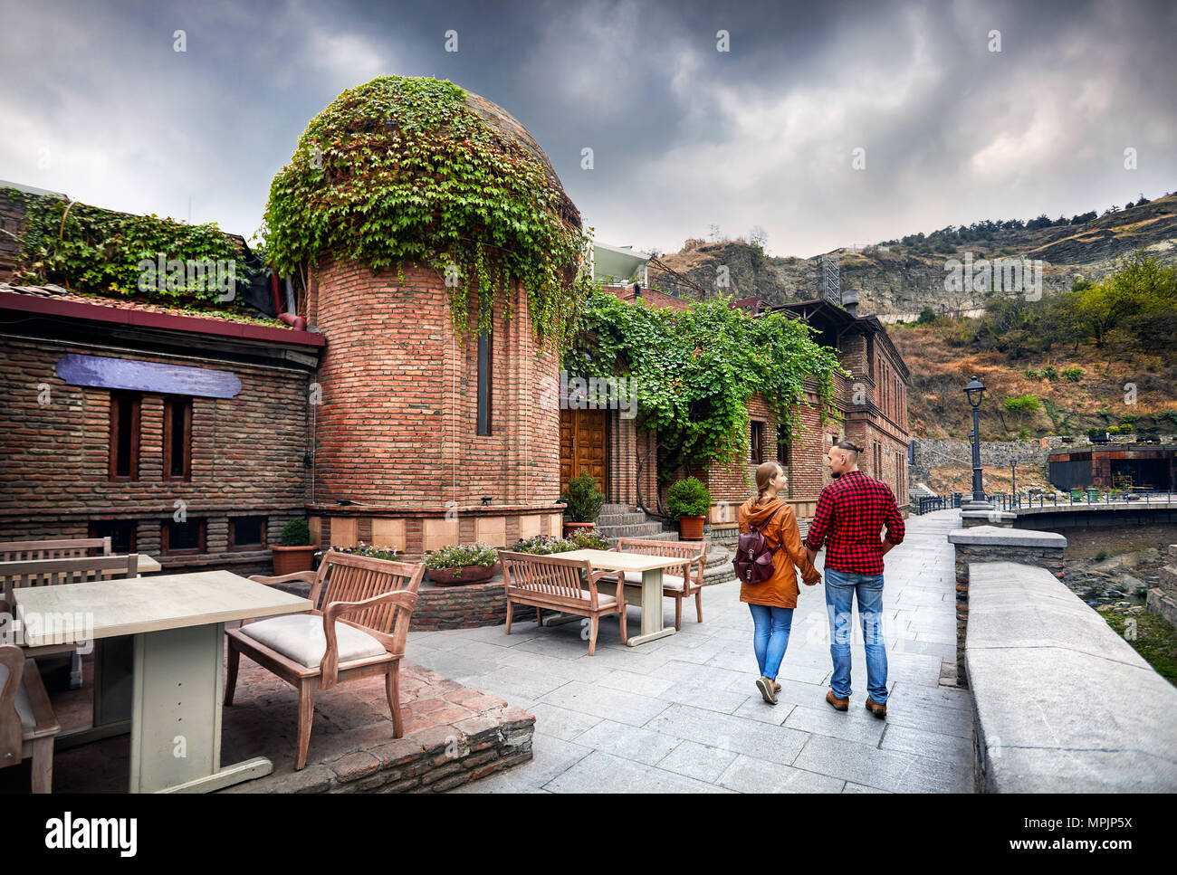 Touristische Frau in braunen Jacke und Mann im roten Hemd, ein Spaziergang entlang der alten Straßen von öffentlichen Schwefelsäure Badewanne Bezirk im Zentrum von Tiflis, Georgien Stockfoto