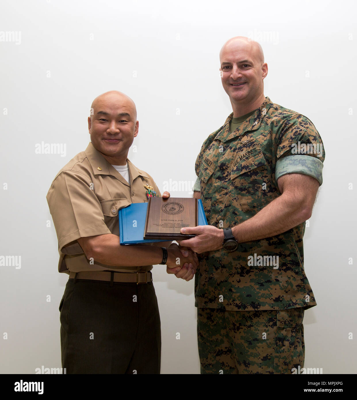 Us Marine Corps Oberst Daniel L. Shipley, Marine Aircraft Group (MAG) 12 kommandierenden Offizier, rechts, stellt US Navy Lieutenant Cmdr. Philip N. Park mit dem Naval Seelsorgestelle Excellence Award für sein herausragendes Engagement für seine Pflicht, so der MAG 12 Kopf kaplan an der Marine Corps Air Station Iwakuni, Japan, 21. März 2017. Die Zeremonie anerkannt Park für die Marines durch die Bereitstellung von religiösen, finanziellen und familiären Beratung. (U.S. Marine Corps Foto von Lance Cpl. Farbo) Jakob A. Stockfoto