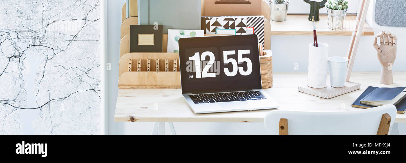 Nahaufnahme von einem Laptop mit Zeit Bildschirmschoner auf home office Schreibtisch platziert Stockfoto