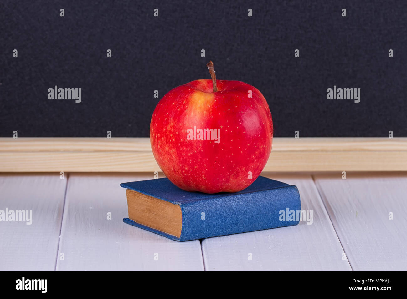 Red Apple auf alten mini Buch gegen Tafel mit Platz für Text. Schule Konzept Stockfoto