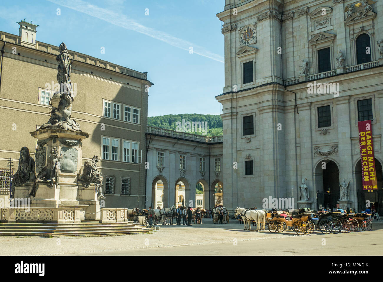 Der barocke Salzburger Dom vom Domplatz aus gesehen. Pferde und Kutschen warten darauf, Touristen für eine Stadtrundfahrt zu nehmen. Stockfoto