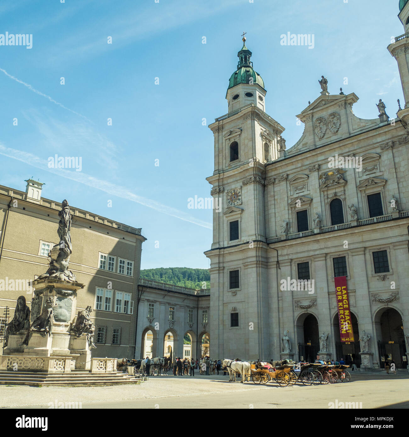Der barocke Salzburger Dom vom Domplatz aus gesehen. Pferde und Kutschen warten darauf, Touristen für eine Stadtrundfahrt zu nehmen. Stockfoto