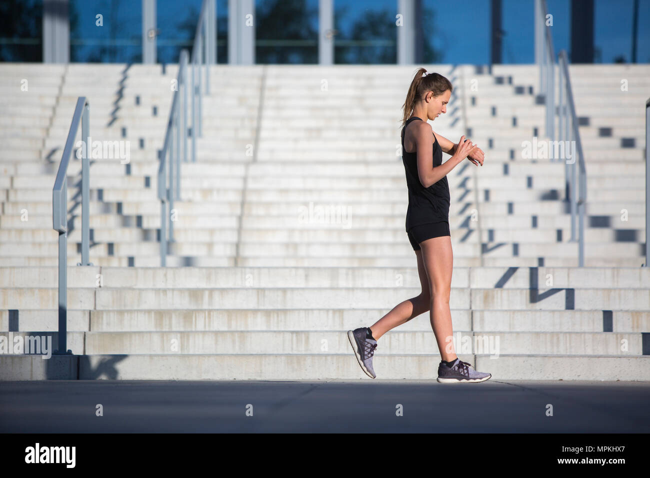 Urban Runner Kontrolle Zeit auf smartwatch Stockfoto