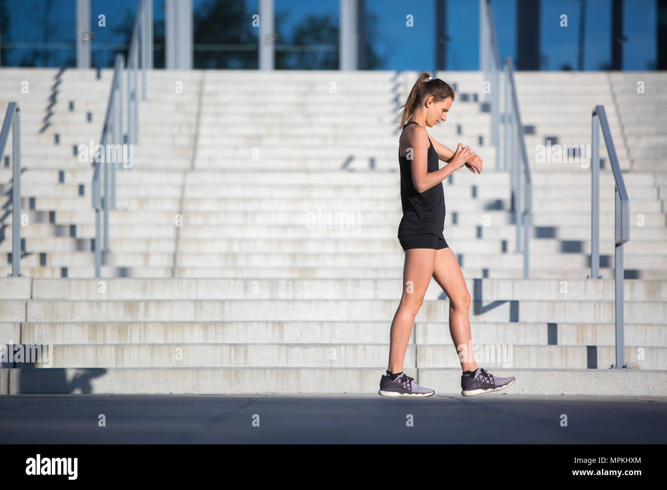 Urban Runner Kontrolle Zeit auf smartwatch Stockfoto