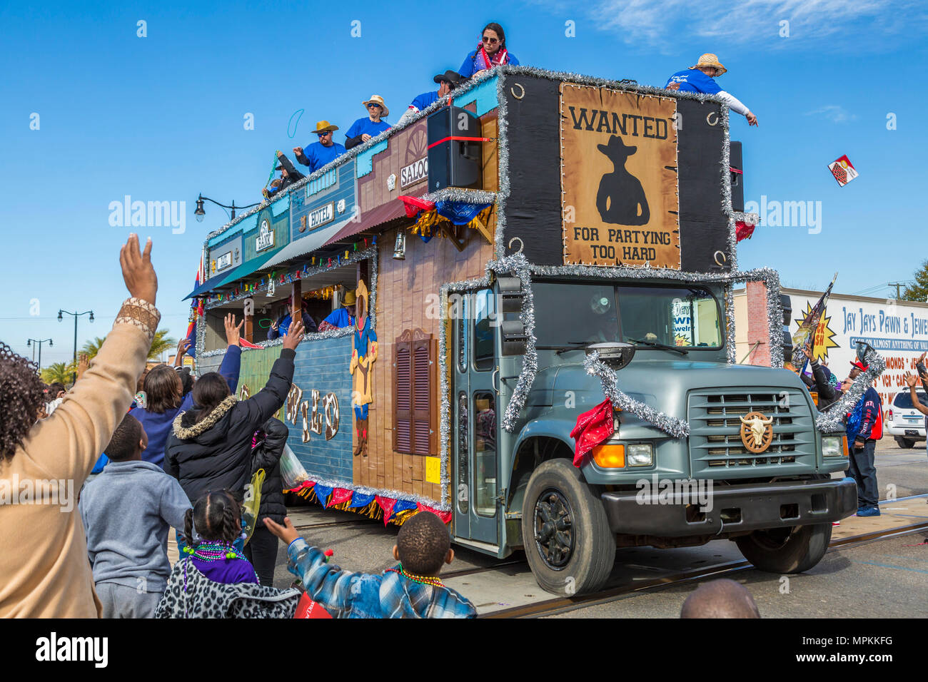 Crew-Mitglieder werfen Perlen von einem westlichen Themenwagen in der Stadt Gulfport Mardi Gras Parade in Gulfport, Mississippi Stockfoto
