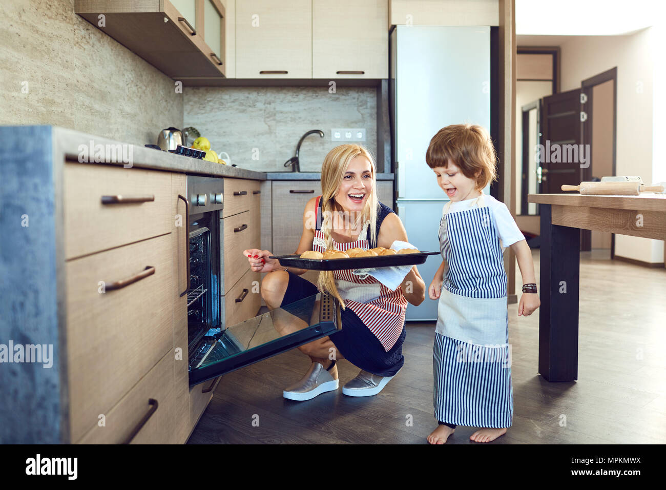 Mutter und Sohn mit Backen in der Küche im Innenbereich Stockfoto