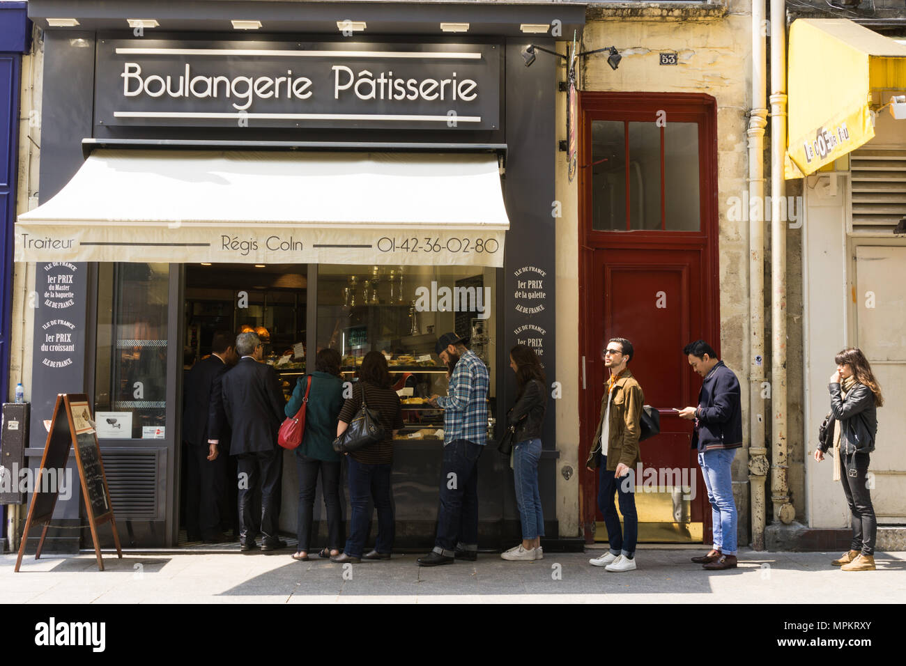 Die Leute Schlange stehen, um ein Brot und Gebäck Shop in Paris, Frankreich. Stockfoto