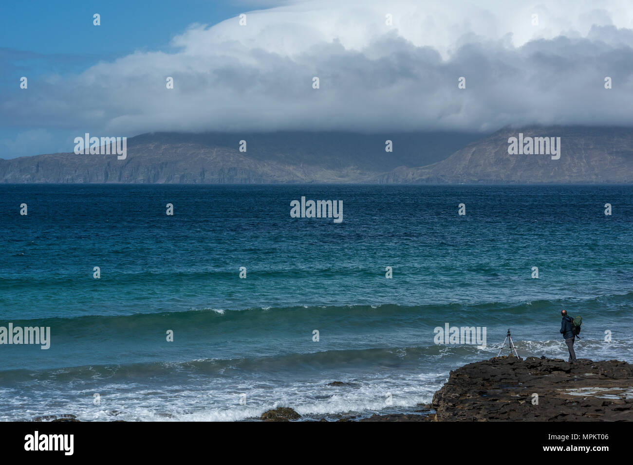 Ein Fotograf in Anbetracht der Aussicht auf der Insel Rum von der Bucht von Laig, Insel Eigg, kleinen Inseln der Inneren Hebriden, Schottland, United Kingdo Stockfoto