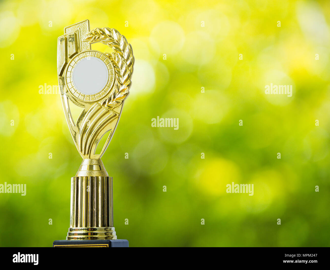 Golden Award Trophäe mit abstrakten Hintergrund des natürlichen Lichts bokeh von Blättern Stockfoto