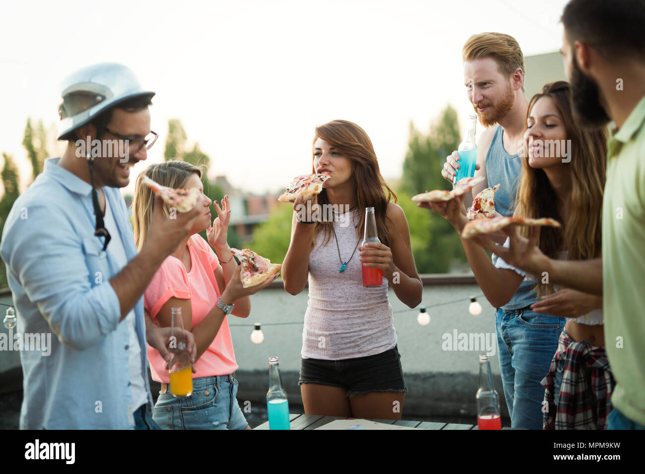 Gruppe junger Leute sitzen herum und essen Pizza Stockfoto