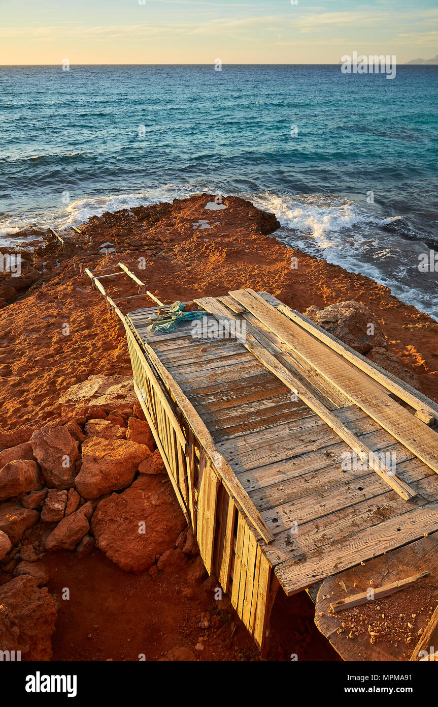 Traditionelles Bootshaus am Meer bei Cala Saona mit der Insel Es Vedrá und der Insel Ibiza in der Entfernung von Formentera (Balearen, Spanien) Stockfoto