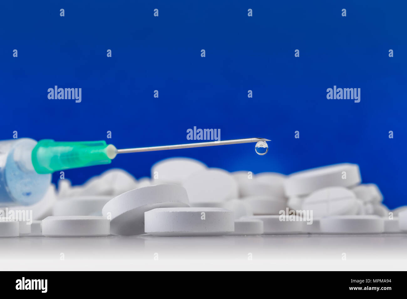 Spritze mit Tropfen an der Spitze der Nadel. Medizinische Werkzeuge. Pharmazeutische Industrie. Stockfoto