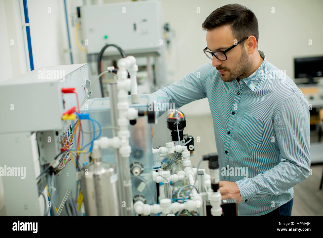 Hübscher junger Mann, der in der elektronischen Werkstatt Stockfoto