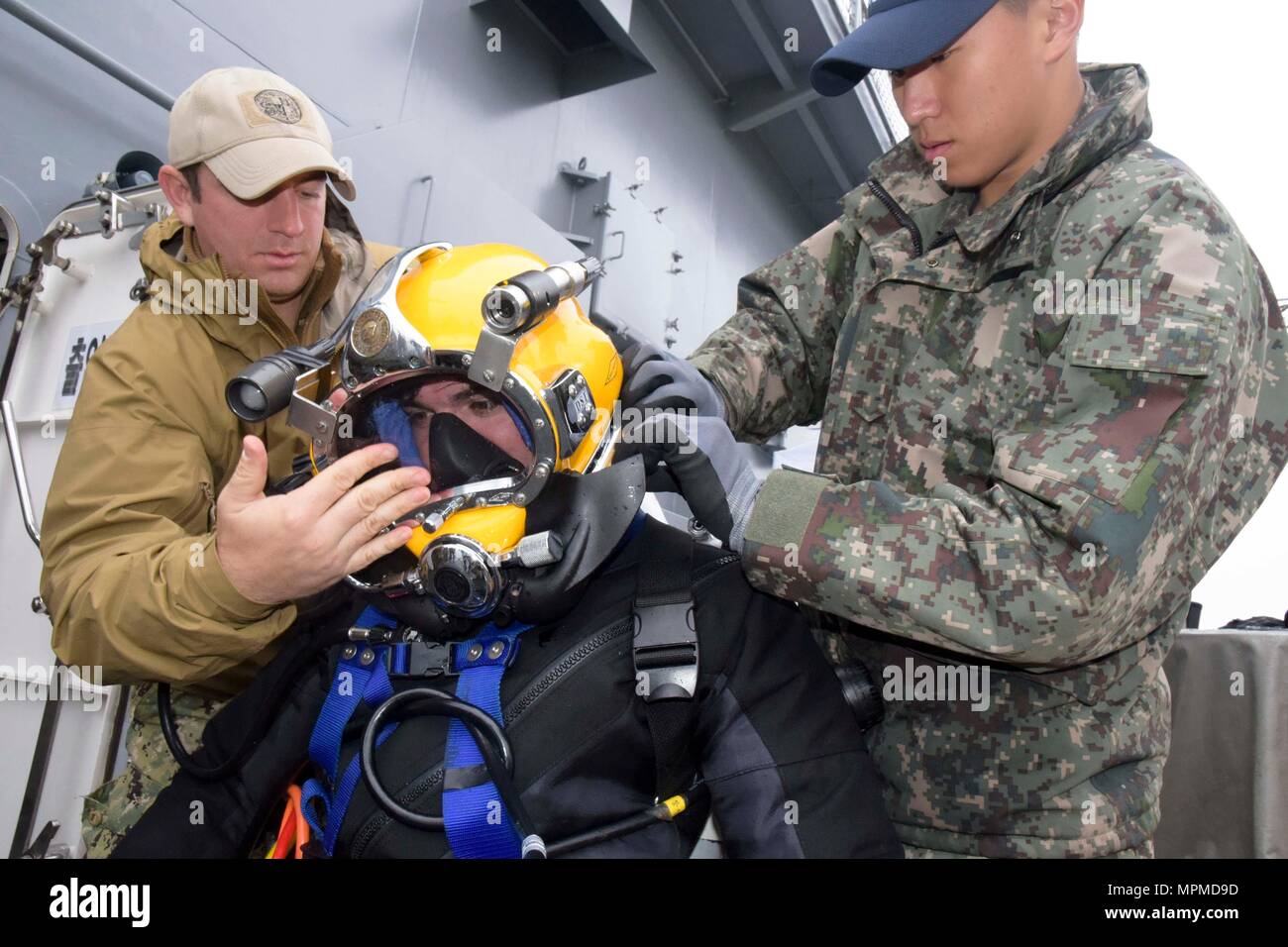 170329-N-CB 621-146 Gewässer, DIE DIE KOREANISCHE HALBINSEL (29. März 2017) Republik Korea (ROK) Marine Hasa (Petty Officer 1st Class) Bae Jun Byum und U.S. Navy Diver 2. Klasse Kyle Fox unterstützen Marine Diver Nick Reese auf Tauchausrüstung, während in der ersten bilateralen Diver Training übung auf ROK Schiff Tong Yeong (ATS 31), während der Bergungsarbeiten Übung (SALVEX) Korea 2017 Teilnehmenden. SALVEX Korea 2017 ist Teil der Übung Fohlen Adler, eine Reihe von gemeinsamen und kombinierten Feld Übungen, was ein Beweis für die Verpflichtung der USA, der Republik Korea und den USA Allianz, und verbessert die Kom Stockfoto