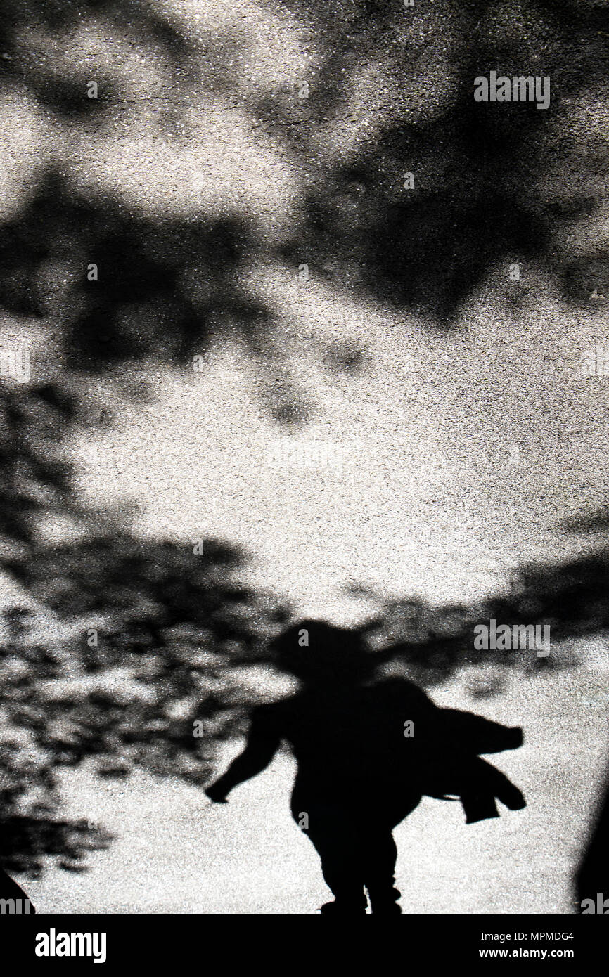 Schatten Silhouette einer Frau und Baumkronen auf Stadt stree in Schwarz und Weiß Stockfoto