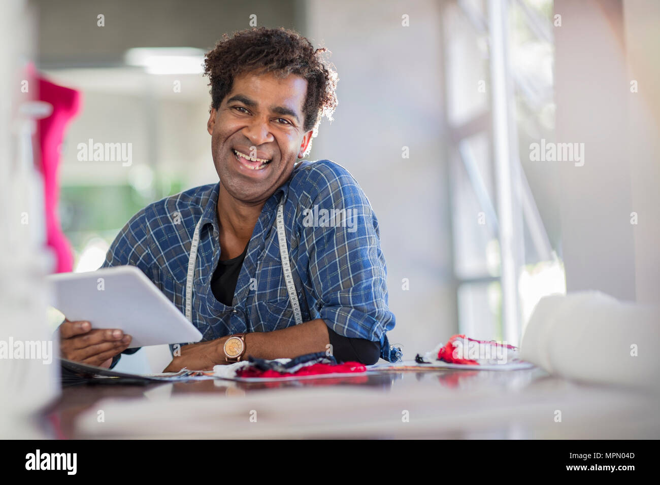 Portrait von Happy Fashion Designer arbeiten mit Tablet-PC auf dem Tisch Stockfoto