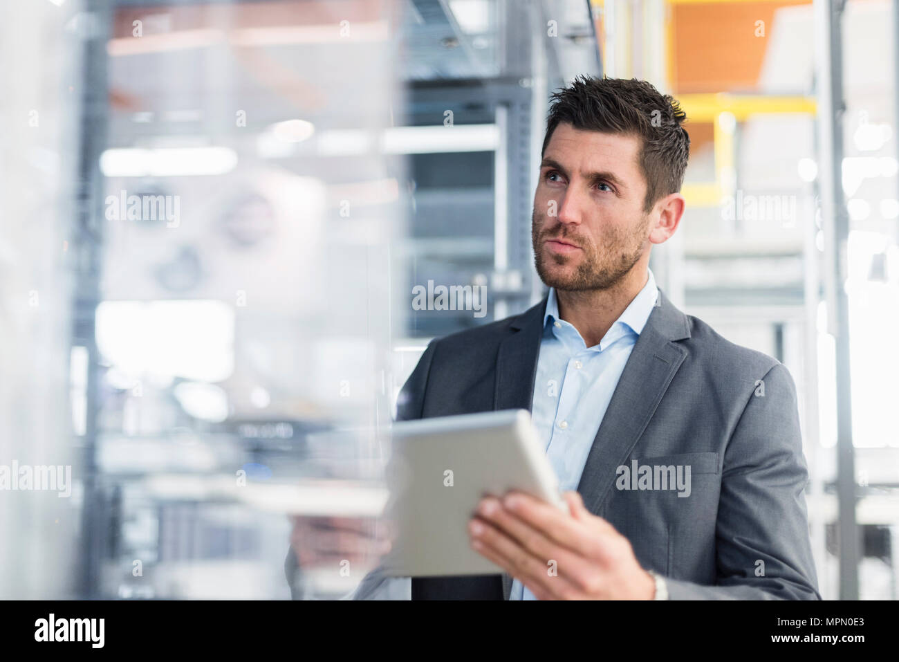 Geschäftsmann mit Tablet in der modernen Fabrik Stockfoto