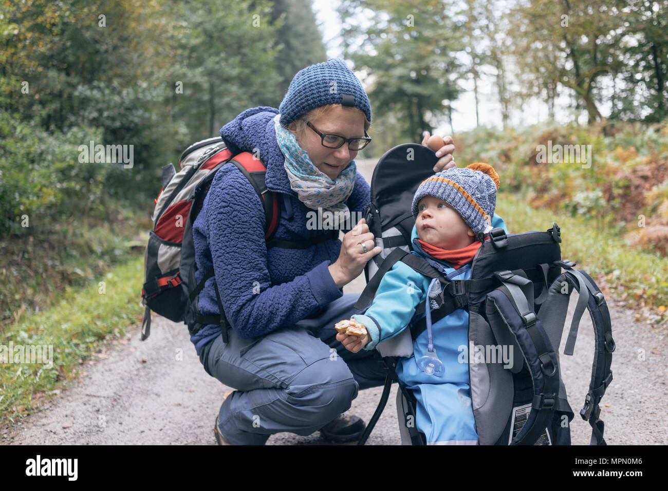 Sohn Brot aß, saß in seinem Back-Korb, neben seiner Mutter während der Wanderungen Stockfoto