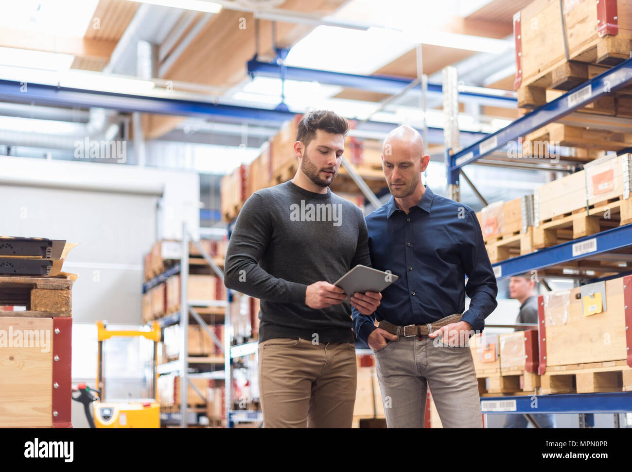 Zwei Männer mit Tablet sprechen in Fabrik Abstellraum Stockfoto