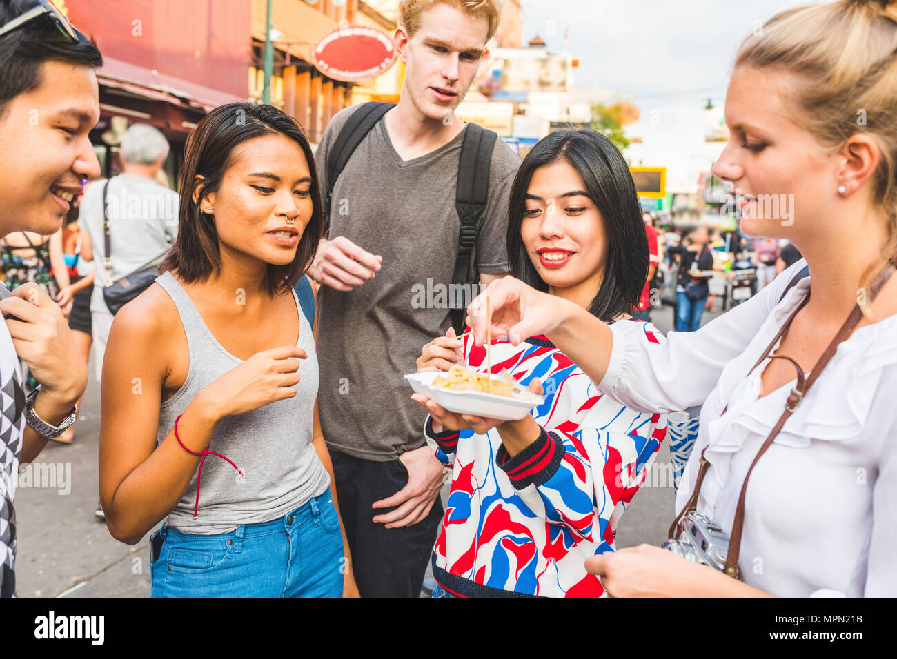 Thailand, Bangkok, Khao San Road, Gruppe von Freunden Verkostung lokaler Lebensmittel auf der Straße Markt Stockfoto