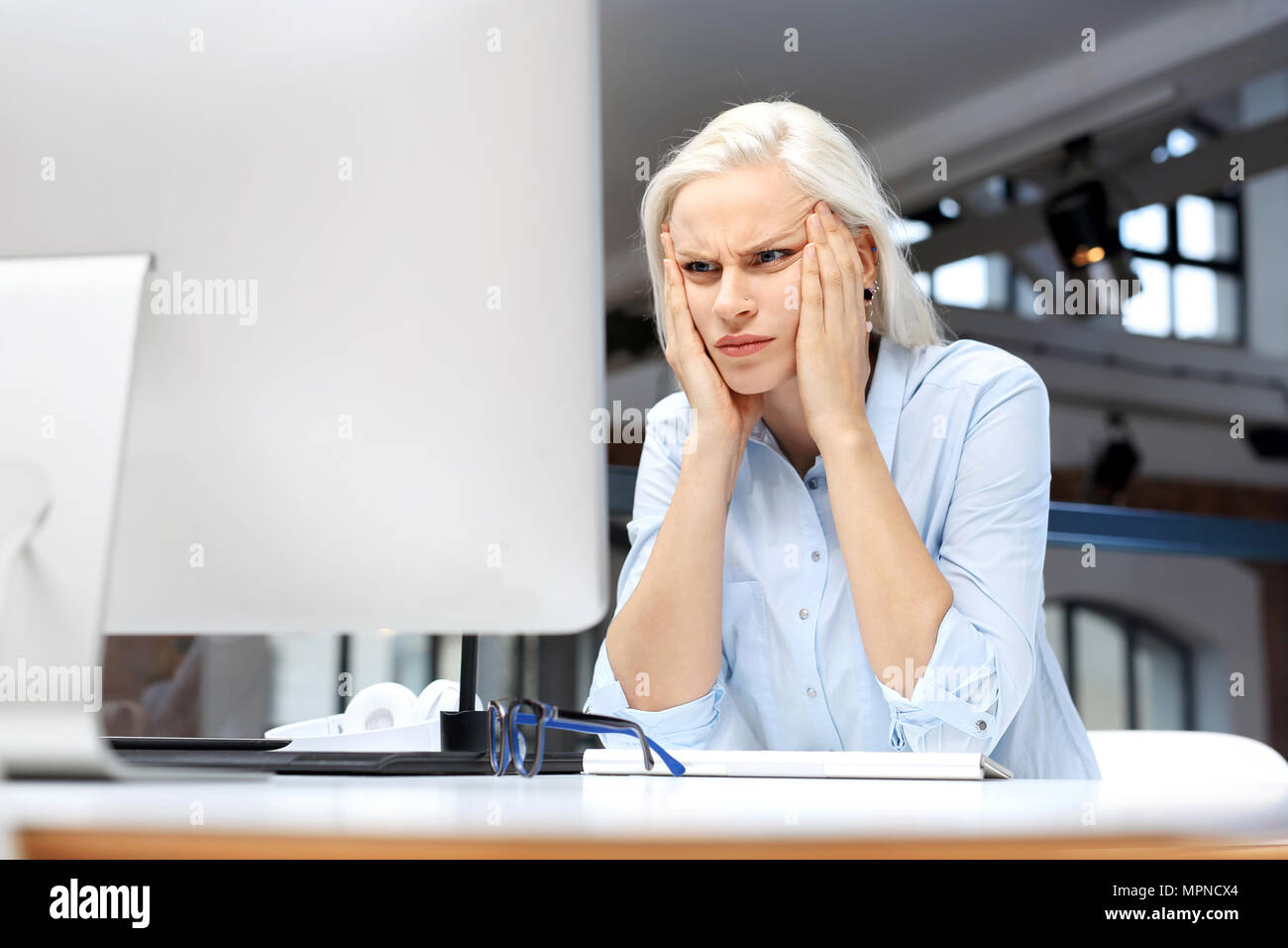 Kopfschmerzen und Müdigkeit bei der Arbeit. Müde Frau am Computer arbeiten Stockfoto