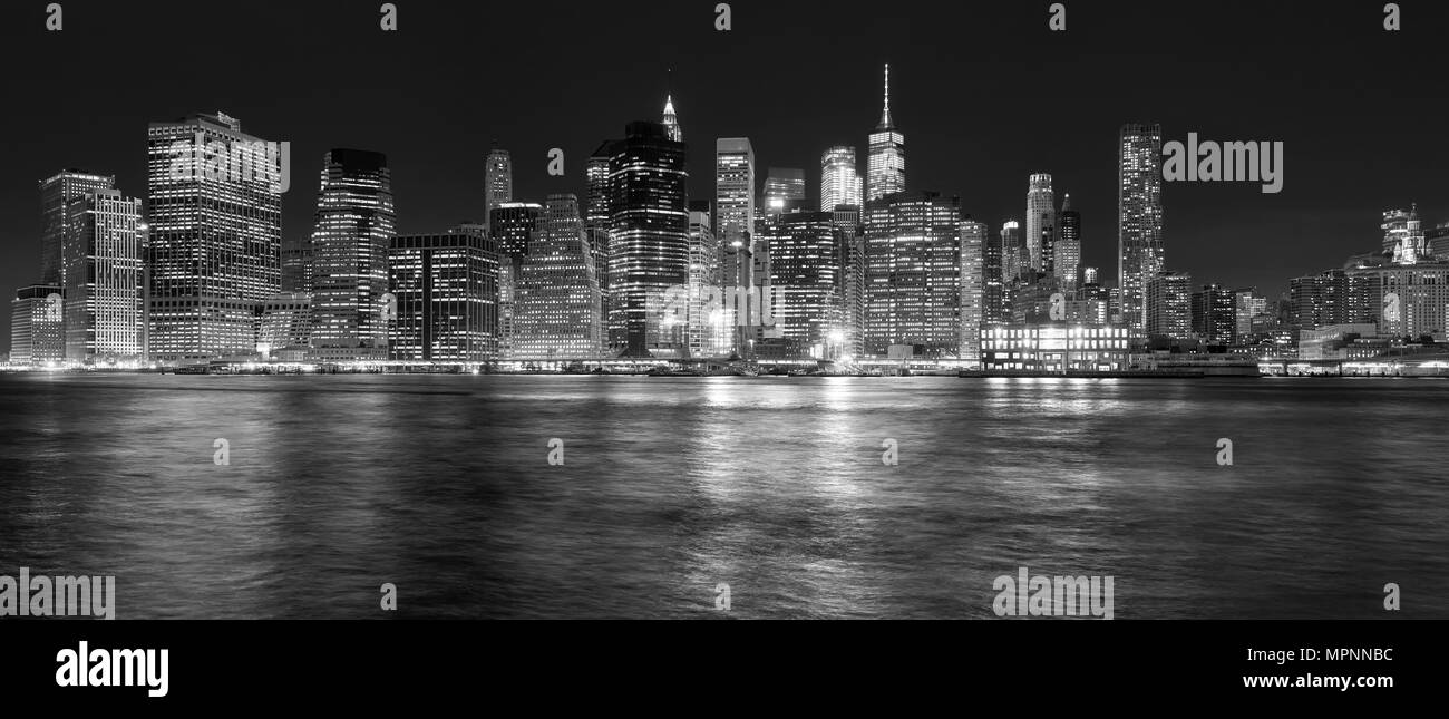Skyline von New York in den East River in der Nacht, USA wider. Stockfoto