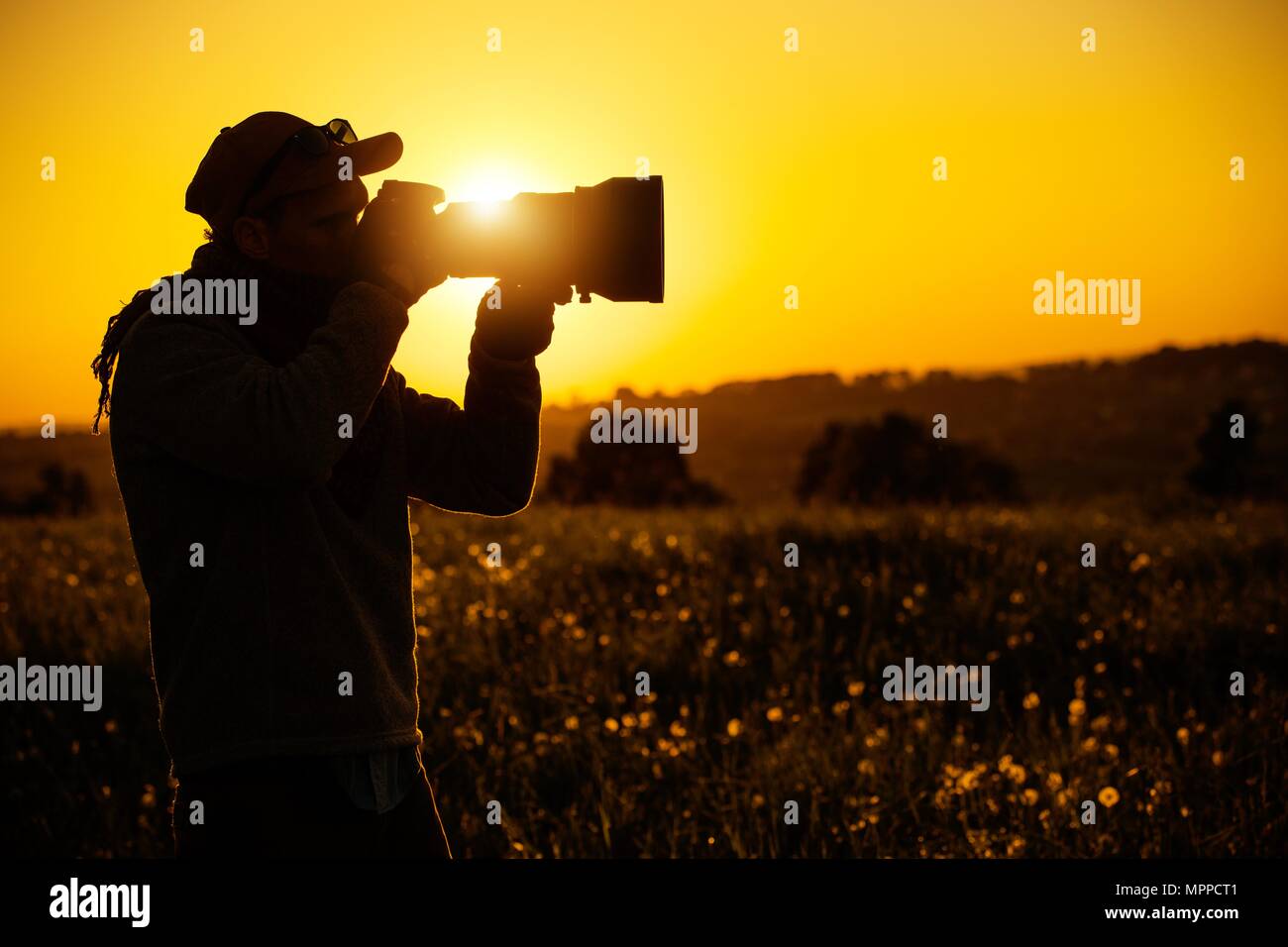 Leidenschaftlich im Freien Fotografen. Einen malerischen Sonnenuntergang Silhouette. Moderne digitale Fotografie Thema. Stockfoto