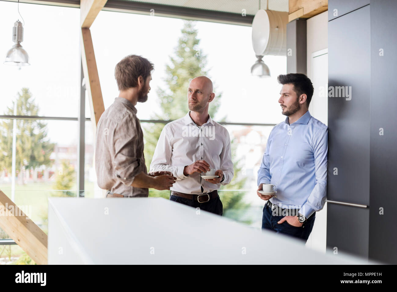 Drei Unternehmer sprechen während der Kaffeepause Stockfoto