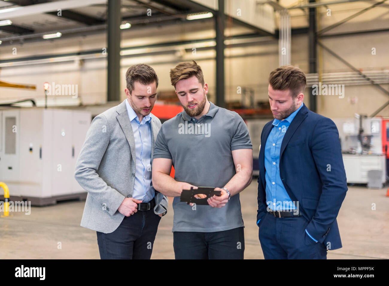 Mitarbeiter erklären Werkstück Geschäftsmänner auf Factory Shop Boden Stockfoto