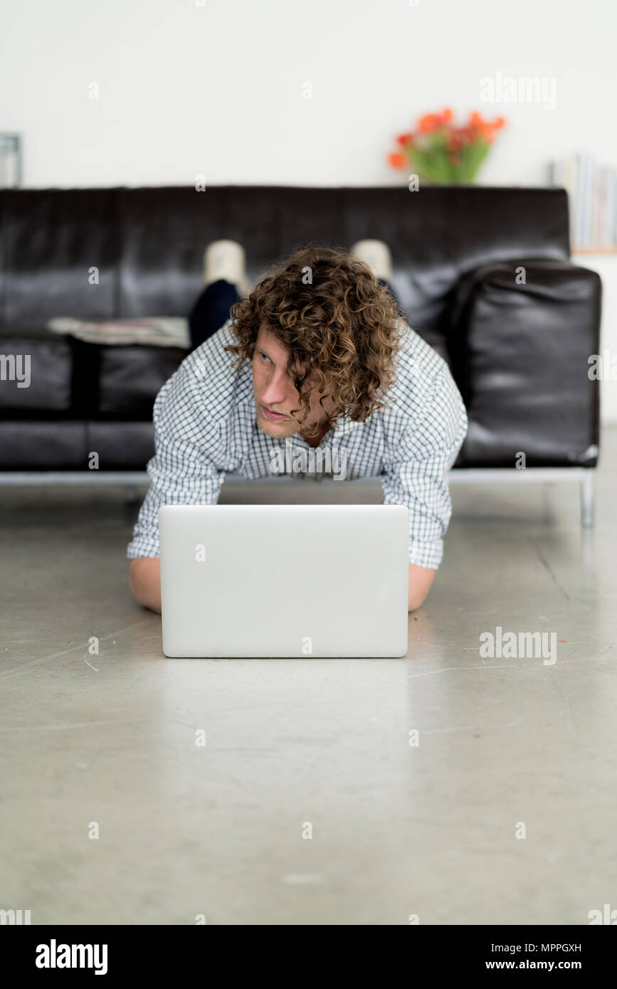 Unternehmer arbeiten von zu Hause mit seinem Laptop, während Sie eine Planke Stockfoto