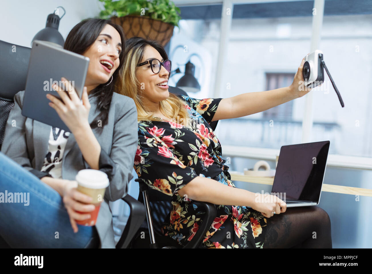 Zwei glückliche junge Frauen im Büro einen selfie Stockfoto