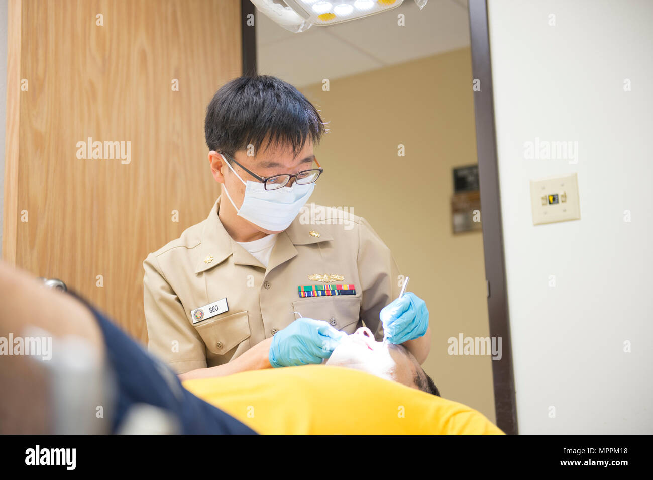 170408-N-OS 584-021 Coronado, Kalifornien (8. April 2017) Lieutenant Commander Youngseok Seo, zur Marine Air Station Branch Klinik zugewiesen, führt regelmäßige zahnmedizinische Prüfung auf Lt.Cmdr. Dustin Burton der Naval Meteorologie und Ozeanographie finden Aktivität 1994 für seine jährliche medizinische Physischen. (U.S. Marine Foto von Mass Communication Specialist 1. Klasse Jimmie Crockett/Freigegeben) Stockfoto