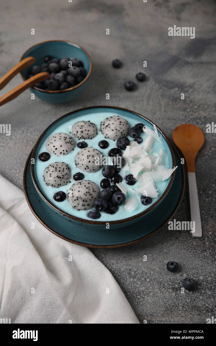 Blau smoothie Schüssel mit Kokosraspeln, Blaubeeren und Drachenfrucht Kugeln Stockfoto