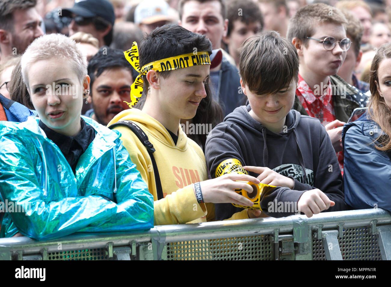 Jungen im Teenageralter in der vorderen Reihe zu einem Musikfestival. Man wickelt sich der andere Arm in 'nicht' Neuheit Band. Stockfoto